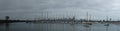 Panoramic of city of Melbourne against a sunny blue sky seen from St Kilda pier looking through the masts of yachts in the bay