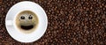 Panoramic coffee background of a cup of black coffee with smiling face coffee bubble on background of roasted arabica coffee beans