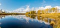 Panoramic colorful landscape with beautiful clouds and trees in the lake, gorgeous trees by the pond, golden autumn