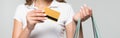 panoramic crop of young woman holding credit card and shopping bags  on grey, black friday concept. Royalty Free Stock Photo