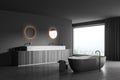 Panoramic dark grey bathroom space with two illuminated mirrors. Corner view Royalty Free Stock Photo