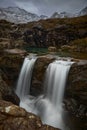 Panoramic double cascade with turquoise water between idyllic landscape of mountains with snow- Fairy Pools - Skye Island -