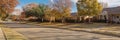 Panoramic empty sidewalk and quite neighborhood street with row of suburban house and colorful fall foliage in Texas, USA Royalty Free Stock Photo