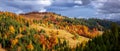 Panoramic fall scenery. Landscape with orange, red, green tree. Fields and forests. The lawn is enlightened by the sun rays.