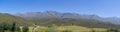 Panoramic farm landscape with high mountains and fields Royalty Free Stock Photo