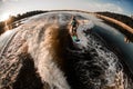 panoramic high angle view of man in turquoise life jacket riding wave on wakeboard Royalty Free Stock Photo