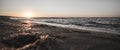 Panoramic horizontal bright warm orange sunset on the evening coast of the Black Sea with warm dark foamy surf waves Royalty Free Stock Photo