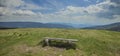 Panoramic hsot of an empty wooden bench in the field near the Ribnica lake in Slovenia