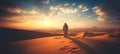 Panoramic image of the desert dusk, rear view of a traveller arabic man walking in the desert among the sand dunes at sunset Royalty Free Stock Photo