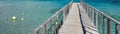 Panoramic image diminishing perspective wooden boardwalk empty path through turquoise Mediterranean Sea Royalty Free Stock Photo
