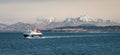 Ferry sailing between Oban and the Isle of Mull with snow capped highland peaks in the background