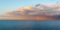 Panoramic image of a heavy rain storm and clouds over the coast of Denmark with a rainbow emerging over the Baltic Sea Royalty Free Stock Photo