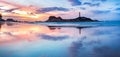 Panoramic Seascape with Clouds Reflected in Water, Island and Lighthouse at Colorful Sunrise Royalty Free Stock Photo