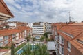 Panoramic image of an open block patio between facades and roofs of urban residential buildings and a playground with swimming