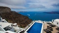 A panoramic image from Santorini with resort swimming pool and sea view to caldera Royalty Free Stock Photo