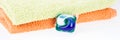 Panorama. Three in one eco gel capsule laundry detergent in front of two towels Royalty Free Stock Photo