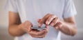 Panoramic image of young caucasian man using apps on a touchscreen smartphone - Hands close-up