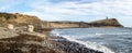 Panoramic Kimmeridge Bay seascape with World War 2 pill box on sea shore and Clavell Tower on cliff top in Kimmeridge, Isle of Pur