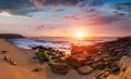 Panoramic landscape of amazing sunset on the ocean. View of dramatic cloudy sky and stony coast. Portugal.