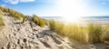 Panoramic landscape background banner panorama of sand dune, beach and ocean North Sea with blue sky, clouds and sunbeams Royalty Free Stock Photo