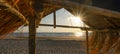 Panoramic landscape background panorama of . Hut with thatched roof in Hawaiian look made of straw on the beach at sunset - Royalty Free Stock Photo