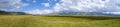 Panoramic landscape of beautiful green mountain valley with blue cloudy sky on background. Spring farm field landscape. Outdoor la Royalty Free Stock Photo
