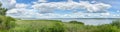 Panoramic landscape with blue lake and reeds ashore Royalty Free Stock Photo