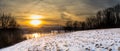 Panoramic view of a sunrise over Blue Marsh Lake with a snowy field in the foreground