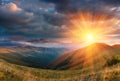 Panoramic landscape of fantastic sunset in the mountains. View of the autumn hills lit by the rays of the evening sun. Royalty Free Stock Photo