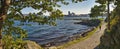 Panoramic landscape with a girl jogging in nature surrounded by ocean and trees in Stavanger city Royalty Free Stock Photo