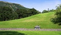 Panoramic landscape of grass field on hill with green forest trees and clear blue sky in Spring and Summer Royalty Free Stock Photo