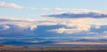 Panoramic landscape of the Khakassia steppes under a cloudy blue sky