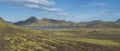 Panoramic landscape with mountain huts at camping site on blue Alftavatn lake with river, green hills and glacier in Royalty Free Stock Photo