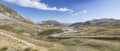 Road bending downhill on barren slopes at Campo Imperatore, from west, Abruzzo, Italy