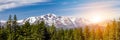 Panoramic landscape scene with sun shining behind the snow capped mountains in Lake Tahoe California Royalty Free Stock Photo