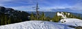 Panoramic Landscape of snow mountain and green trees.