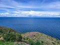 Panoramic landscape with view of the Andean lake bay and beach with trees on a clear day