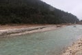 Panoramic landscape view of beautiful Teesta river with snowfall and pine forests at Yumthang valley. It is the largest river in Royalty Free Stock Photo