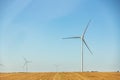 Panoramic landscape view of new white modern wind turbine farm power generation station against clear blue sky and field Royalty Free Stock Photo