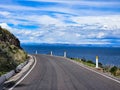 Panoramic landscape with view of road on cliff at the edge of lake in spring and sunny day Royalty Free Stock Photo