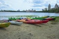 Panoramic landscape view of several colorful kayaks at the river shore. Boats on the city sandy beach, Obolon, Kyiv, Ukraine. Royalty Free Stock Photo