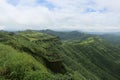Panoramic landscape view of strong perimeter wall of ancient Sinhgad fort in beautiful lush green Sahyadri mountains in Pune, Royalty Free Stock Photo