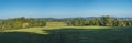 Panoramic late summer landscape with idyllic green meadow, trees, forest and hills with clear blue sky, Czech republic Royalty Free Stock Photo