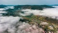 Panoramic mountains in the fog and clouds. Sunset with fog. Landscape format.