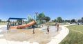 Panoramic multicultural kids and parent playing at splash park in Texas in post COVID-19 pandemic