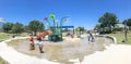 Panoramic multicultural kids and parent playing at splash park in Texas in post COVID-19 pandemic