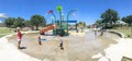 Panoramic multicultural kids and parent playing at splash park in Texas in post COVID-19 pandemic