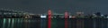 Panoramic nightview of Rainbow Bridge, illuminated in red as a sign of coronavirus alert