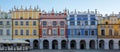 Panoramic photo of brightly coloured renaissance buildings in the historic Great Market Square in Zamosc in southeast Poland.