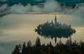 Panoramic photo of lake Bled island with church on a cold hazy foggy early autumn morning from Ojstrica vantage point. Visible Royalty Free Stock Photo